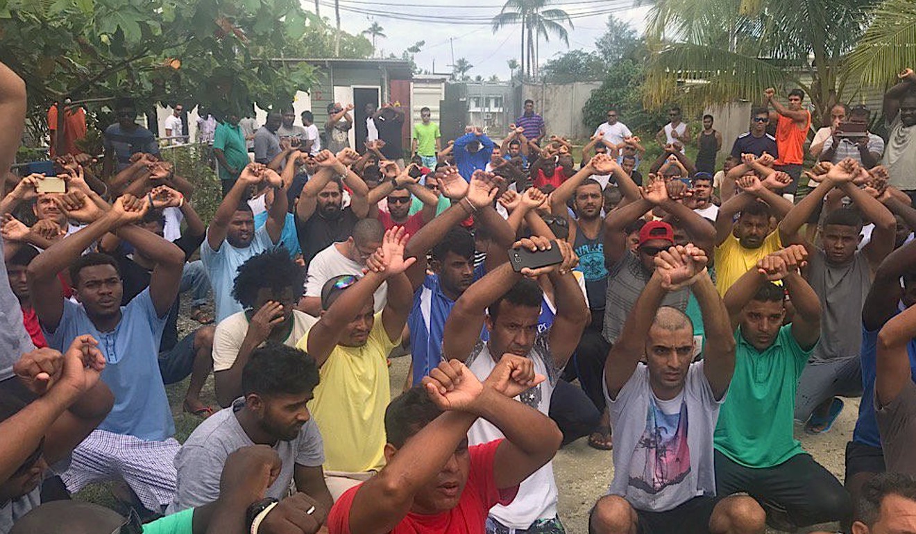 Detainees raise their arms in protest at the Manus Island detention centre. Photo: Reuters