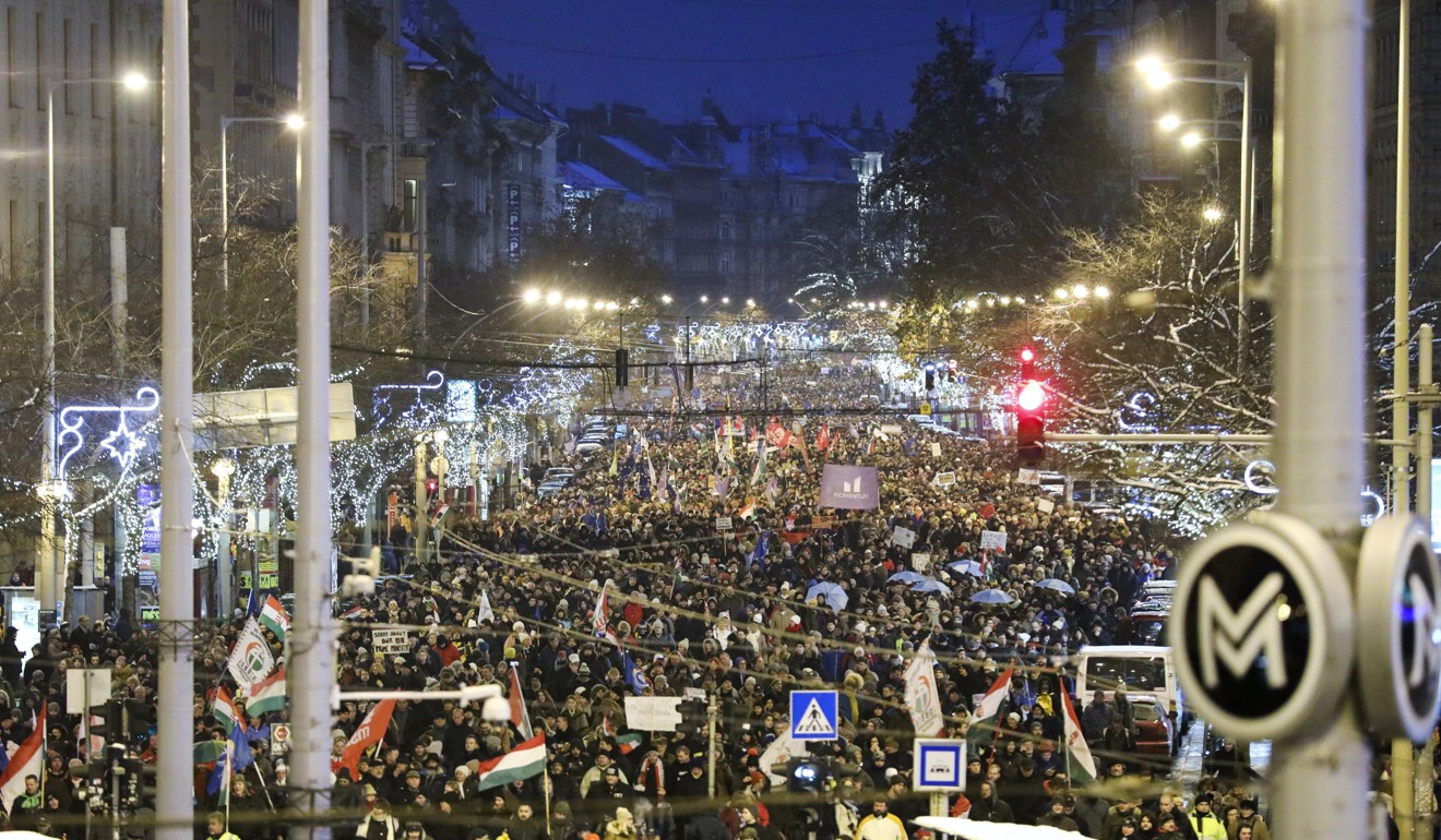 Anti-government demonstrators march under Christmas decorations in Budapest. Photo: AP