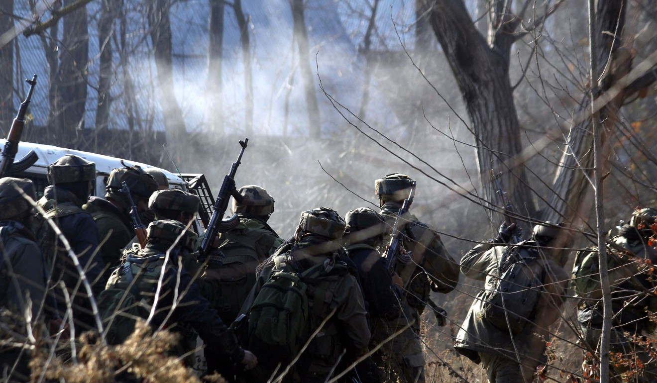 Indian troops take cover near the site of a gun-battle between militants and government forces in Sirnoo Pulwama south of Srinagar. Photo: AFP