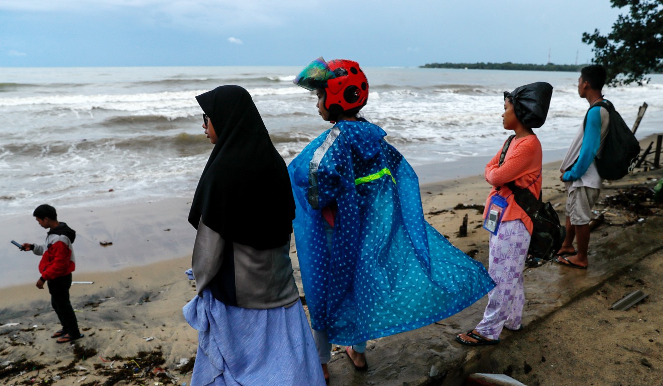 Locals affected by the tsunami stand on Carita beach on December 24, 2018. Photo: Reuters