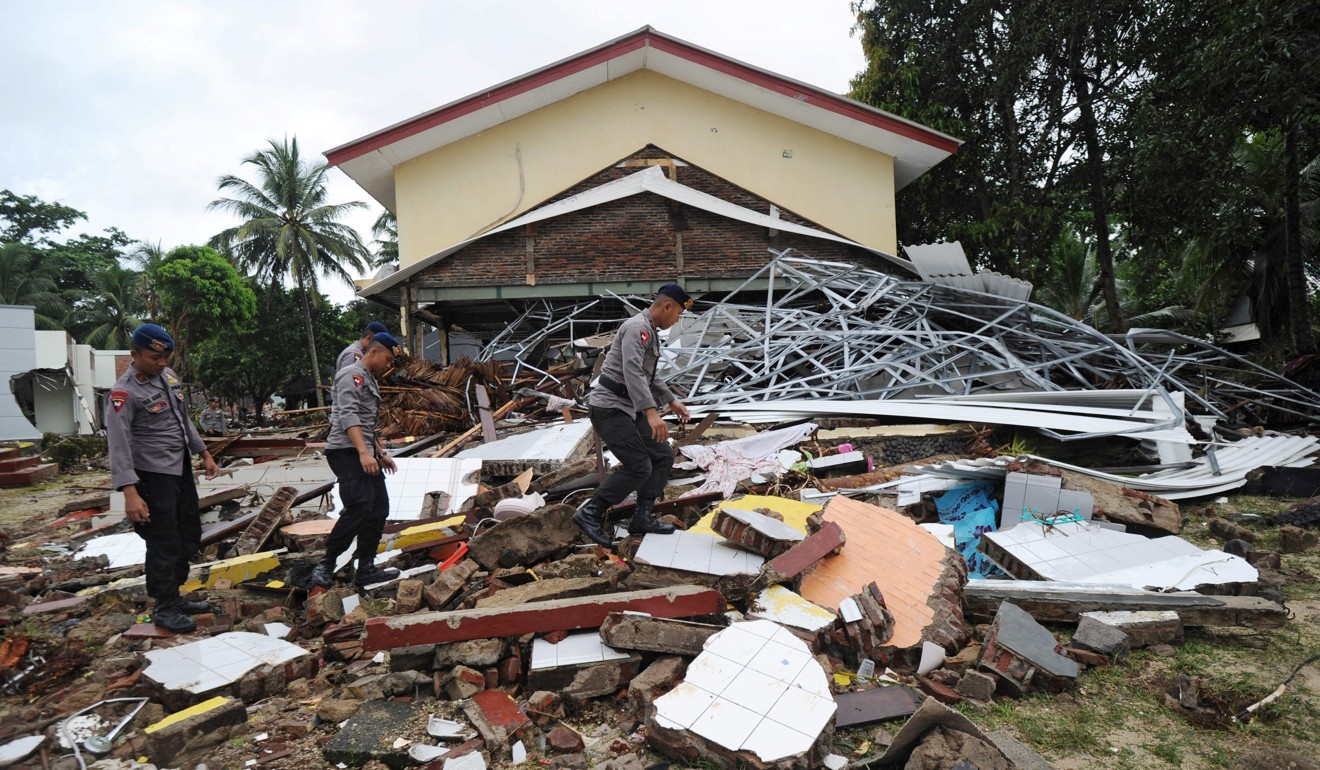 Police search for victims among debris at the Mutiara Carita Cottages in Carita on December 24. Photo: AFP