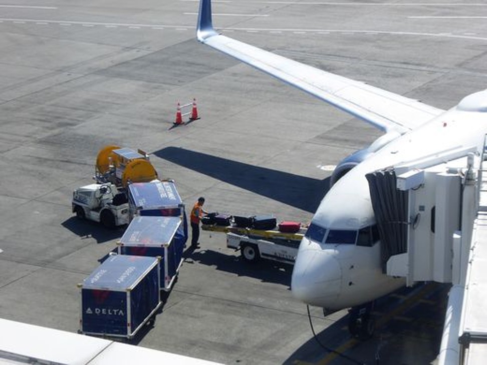 Bags are transferred from a cart to a plane. Photo: Harriet Baskas for ‘USA TODAY’