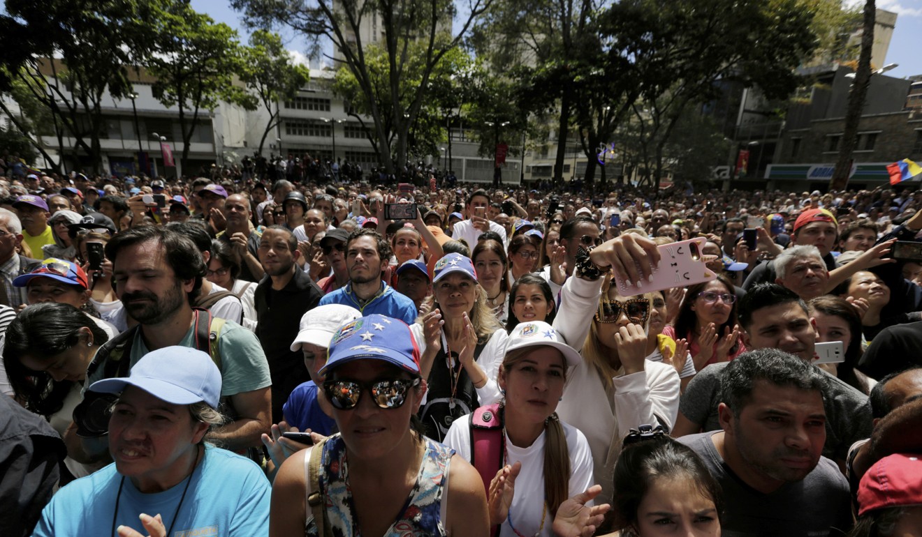 Supporters of Guaido listening to him speak in Caracas on Friday. Photo: AP