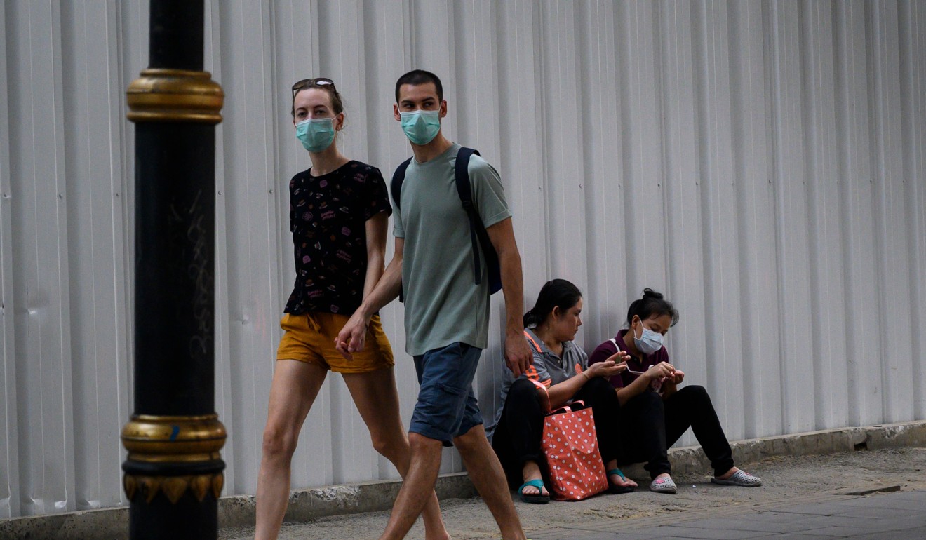 Pedestrians wearing face masks in Bangkok. Photo: AFP