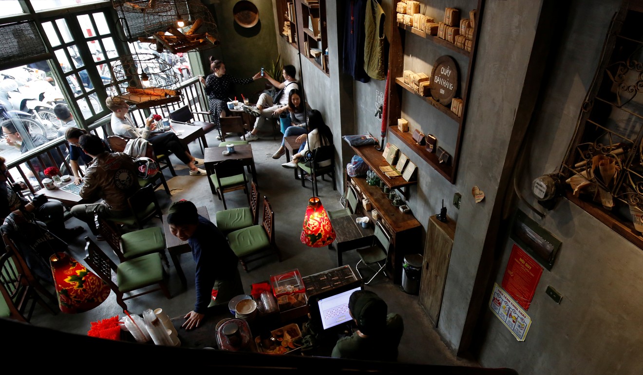 Customers inside Cong Ca Phe, a popular cafe chain which uses communist-era propaganda in its branding. Photo: Reuters