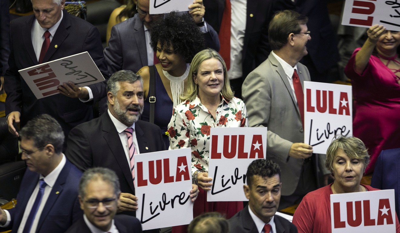 Opposition deputies hold posters in support of imprisoned former president Luiz Inacio Lula da Silva. Photo: EPA