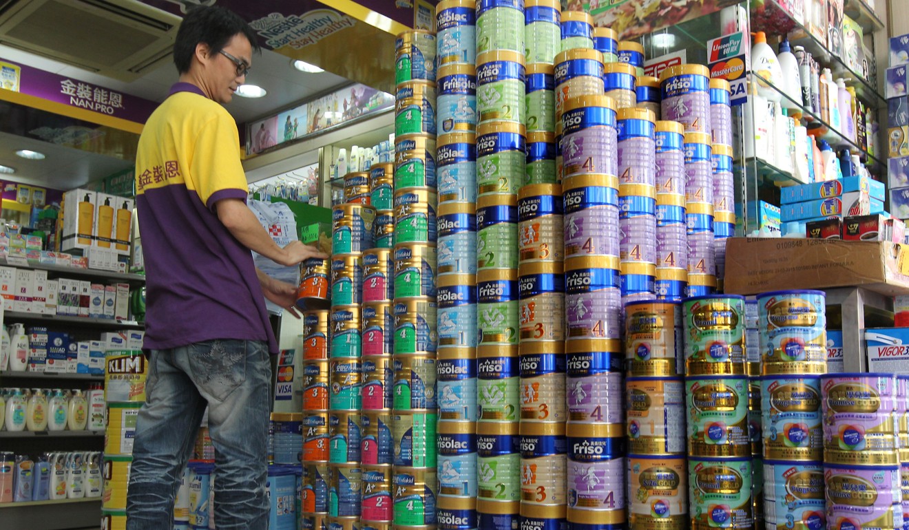 Employees stock a pharmacy with baby milk formula in Sheung Shui. Photo: K.Y. Cheng