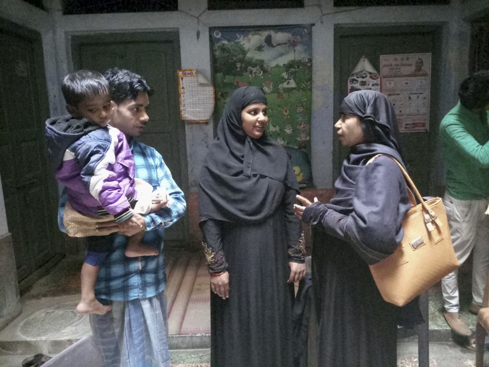 A social worker (right) in Varanasi explaining to parents Nusrat Bareen and her husband when to come in again for their child’s next vaccination. Photo: Amrit Dhillon