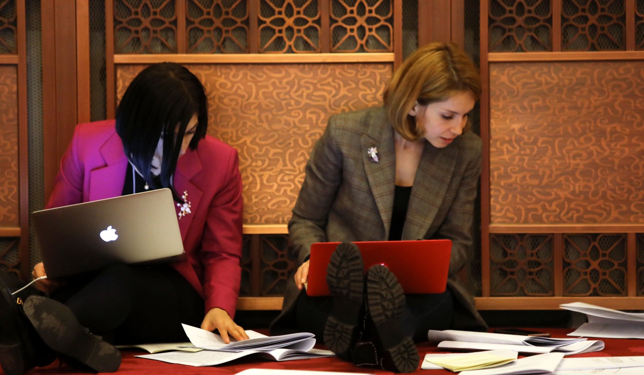 Two reporters scan their copies of the report. Photo: Simon Song