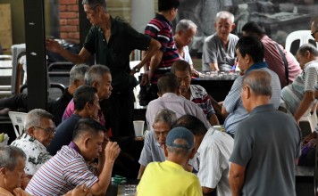 Elderly residents play board games in the Chinatown district of Singapore. Photo: AFP