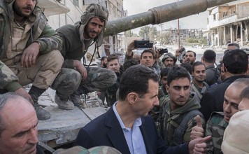 A handout photo made available by the official Syrian Arab News Agency (SANA) shows Syrian president Bashar Al-Assad meeting with Syrian army soldiers, in eastern Ghouta, on March 18, 2018. Photo: SANA handout via EPA-EFE