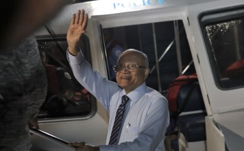 Maldives former president Maumoon Abdul Gayoom waves as he is brought to appear before the High Court in Male, Maldives, where he has been granted bail. Photo: AP