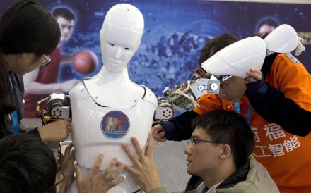 Chinese students work on a humanoid robot designed by them with funding from a Shanghai investment company, at the World Robot Conference in Beijing, last October 21. Photo: AP