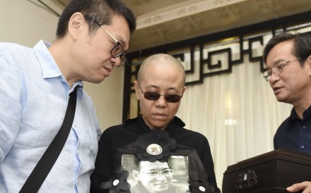 Liu Xia (centre), wife of late Nobel Peace Prize winner Liu Xiaobo, holds a portrait of her husband during his funeral in Shenyang in July. Supporters said they contacted her on Saturday. Photo: AP Liu Xia (centre), wife of late Nobel Peace Prize winner Liu Xiaobo, holds a portrait of her husband during his funeral in Shenyang in July. Supporters said they contacted her on Saturday. Photo: AP