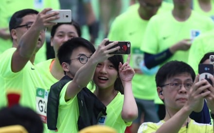 Runners take selfies at the Hong Kong Marathon finish line in Victoria Park. Photo: Nora Tam