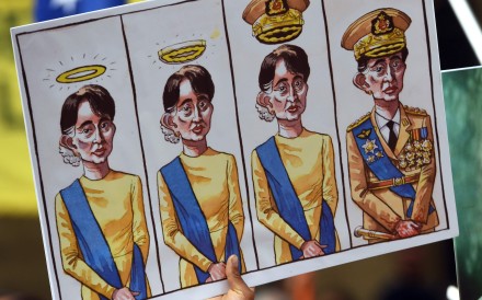 Posters with cartoons featuring Myanmar’s State Counsellor Aung San Suu Kyi are held up at a protest in Sydney on March 17, 2018. Photo: AFP