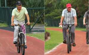 Trainers Tony Cruz and Tony Millard ride bicyles to watch their horses. Photos: Kenneth Chan