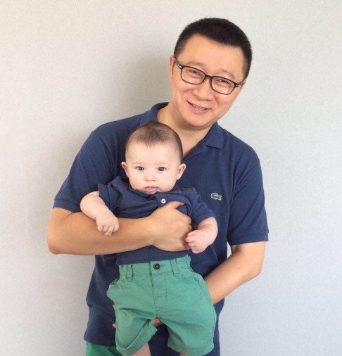 Ma Baoli holds his son, Xiao Shu, born through a surrogacy agency in the US.
