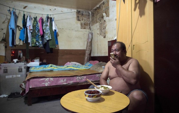 Liu Huiqing, who works in a private company, talks on the phone inside his room, as he eats dinner in a migrant village. Photo: AFP Liu Huiqing, who works in a private company, talks on the phone inside his room, as he eats dinner in a migrant village. Photo: AFP