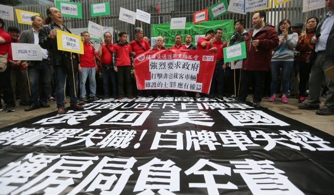 Hong Kong taxi drivers ask Uber to "go back to America" at a protest in March.