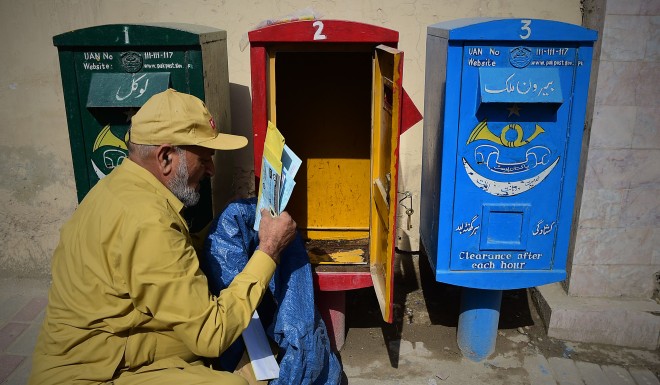 A Pakistani postman collects posts during World Post Day on October 9. The day commemorates the anniversary of the Universal Postal Union.