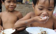 Filipino slum children eat a meal of rice, noodles and fish. Families in Asia get a higher proportion of energy from carbohydrates than those in the West. Photo: AFP