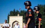 Chinese police patrol outside a mosque in Xinjiang as Muslims leave morning prayer in June 2017. Photo: AFP