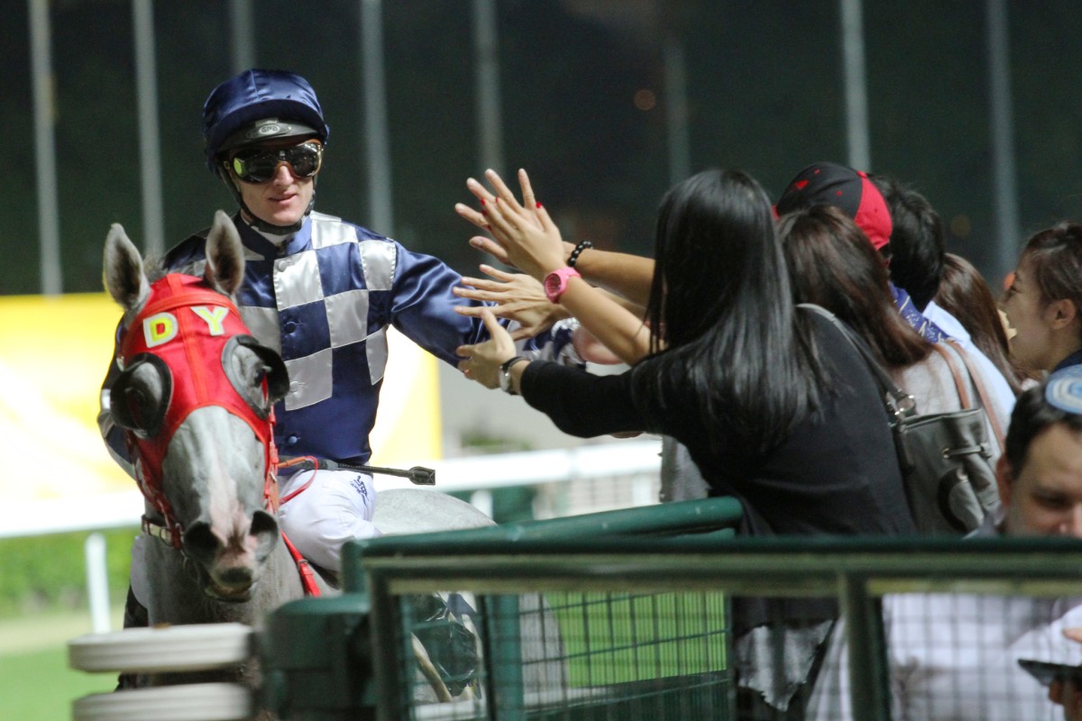 Zac Purton high-fives adoring fans after winning the Ireland Trophy with Choice Treasure. Photo: Kenneth Chan  