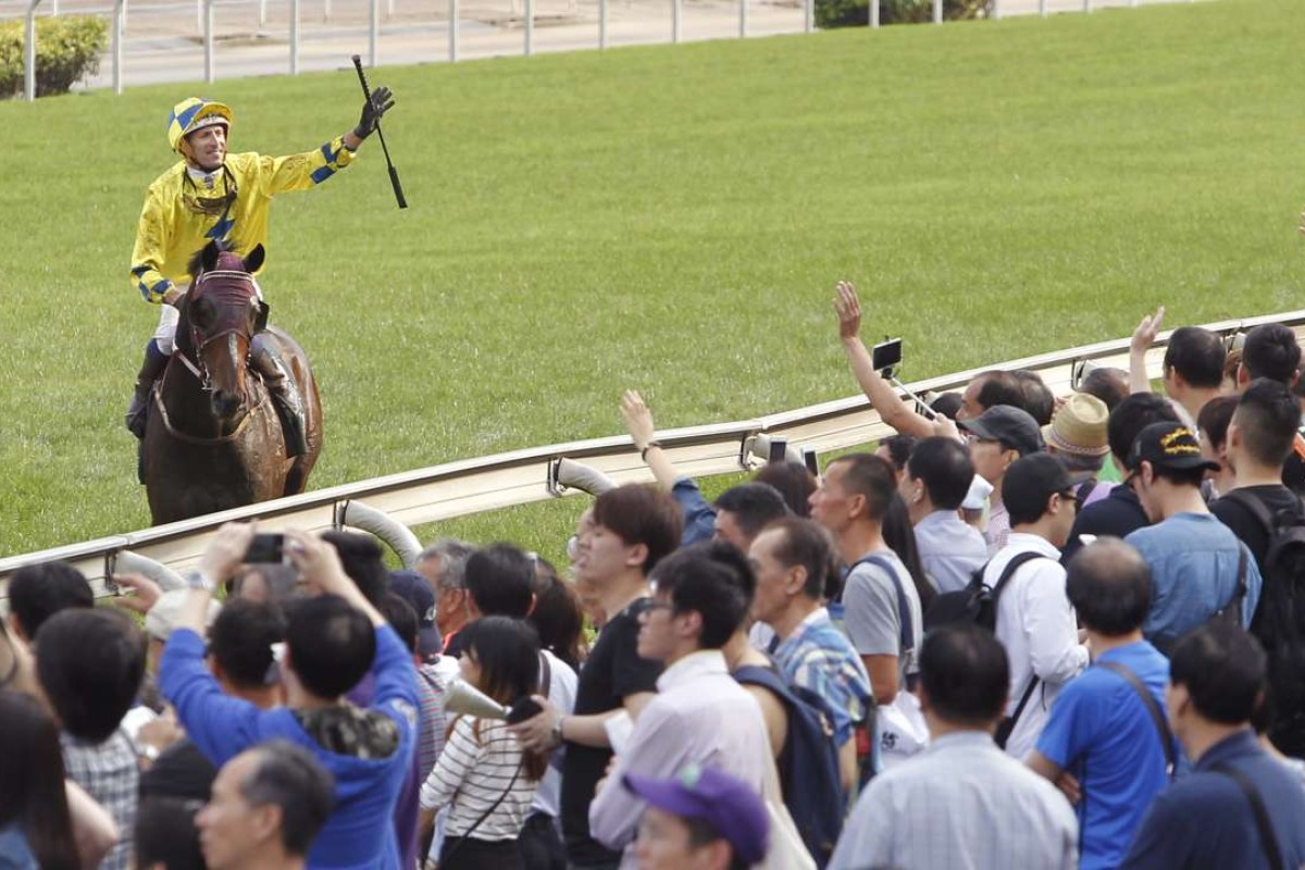 Hugh Bowman salutes the crowd after winning the QE II Cup on Werther. Photos: Kenneth Chan