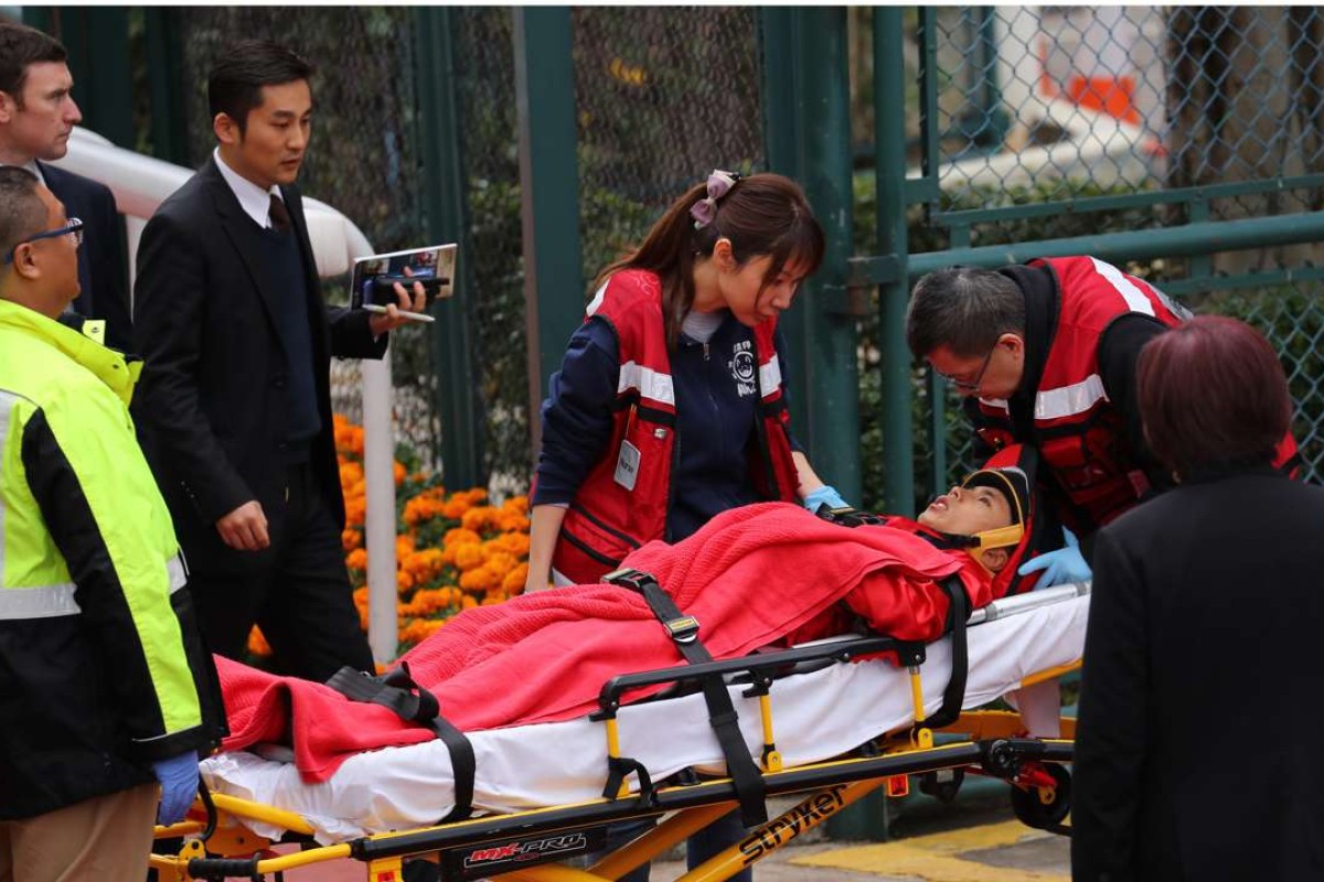 Matthew Poon gets taken to an ambulance after being injured by his horse General Iron leaving the mounting yard. Photos: Kenneth Chan