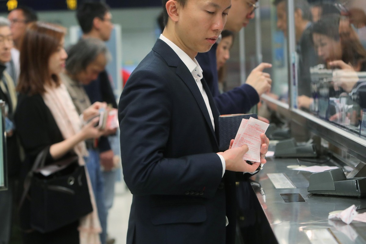 Punters line up to place bets at a Hong Kong Jockey Club off-course betting branch in Central. Photos: Winson Wong